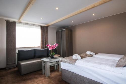 um quarto de hotel com duas camas e um sofá em Ania Apartamenty em Chochołów