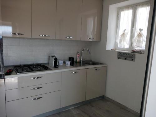 a kitchen with white cabinets and a sink and a stove at Villa Patrizia in La Spezia