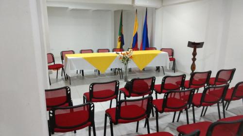 a conference room with a table and red chairs at Hotel Bahía Yubarta in Bahía Solano