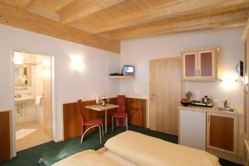 Habitación pequeña con cocina, mesa y cama en Apart la Montagnia, en Kappl