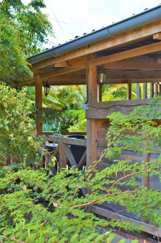a wooden pergola in a garden with plants at Jan Kok Lodges in Willibrordus