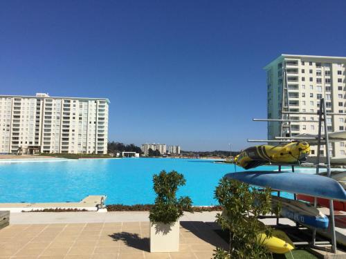 a large swimming pool with buildings in the background at Departamento en Laguna Bahia in Algarrobo