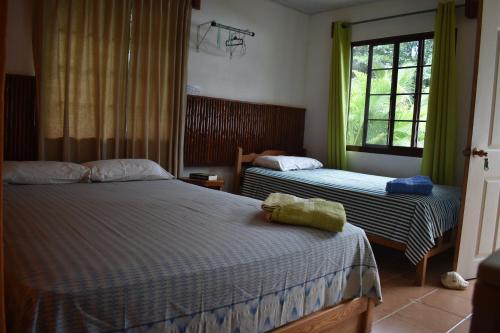 a bedroom with two beds and a window at Rainforest Yasmin Hotel in Santa Fe