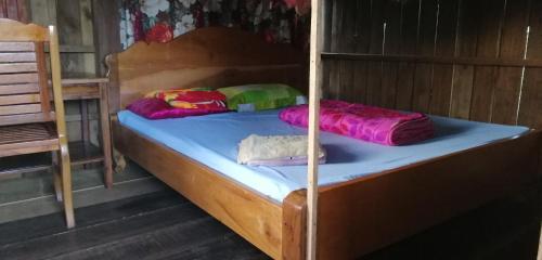 a bunk bed with colorful sheets and pillows on it at Tree Trails Homestay & Offers Jungle Trekk-Scooter For Rental in Banlung