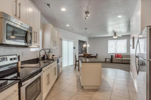 a kitchen with white cabinets and a living room at Spacious & New Guesthouse in Orem/Provo in Orem