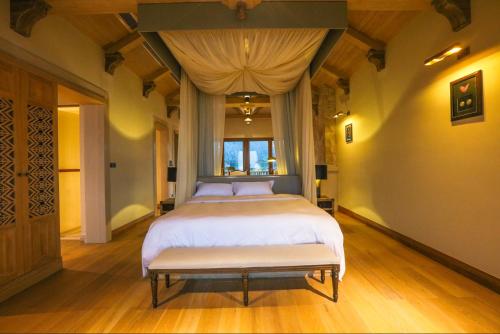 a bedroom with a large bed and a bench at Evergreen Retreat-walk to National Forest Park, free pick up service in Zhangjiajie