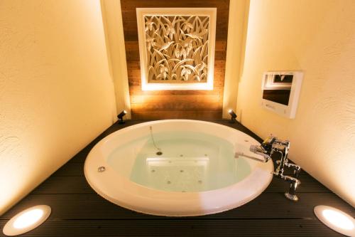 a bathroom with a large white tub in a room at Hotel Atlantis Higashi Osaka (Adult Only) in Osaka