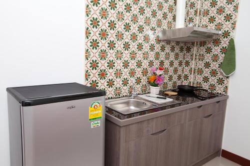 a small kitchen with a sink and a refrigerator at The BluEco Hotel SHA Plus in Kata Beach