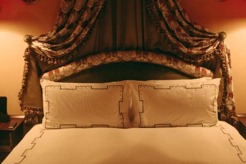 a bed with an ornate headboard with two pillows at L'Escape Hotel in Seoul