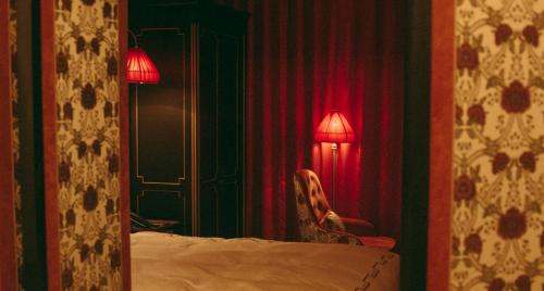a room with a bed and a lamp and a chair at L'Escape Hotel in Seoul