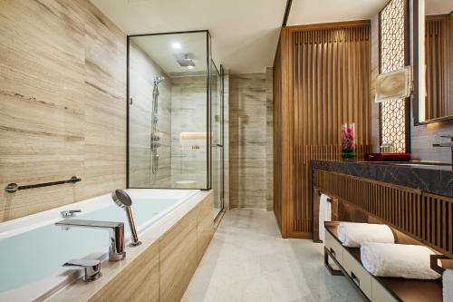 a bathroom with a tub and a shower at Ascott Riverside Garden Beijing in Beijing