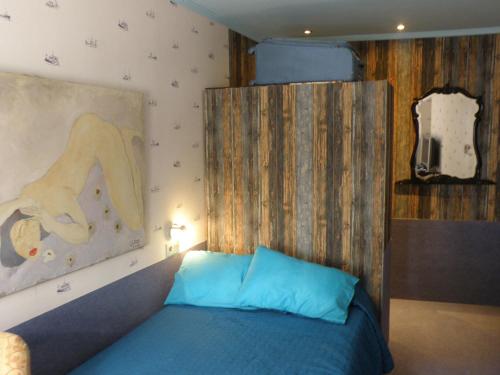 a bedroom with a bed with a painting on the wall at La NANA del MAR / The LULLABY of the SEA on old harbour in Cudillero