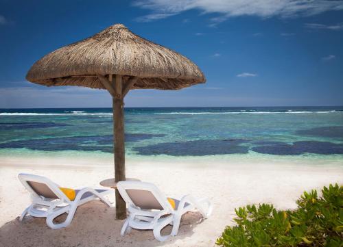 two chairs under an umbrella on the beach at Radisson Blu Poste Lafayette Resort & Spa (Adults Only) in Poste Lafayette