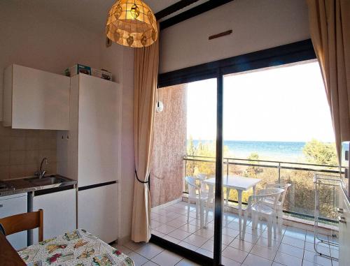 une cuisine avec une table et une vue sur l'océan dans l'établissement Résidence les Marines de Moriani Emeraude Locations, à Moriani-Plage