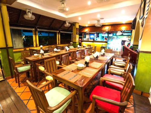 a dining room with wooden tables and chairs at Casa E Mare in Kata Beach
