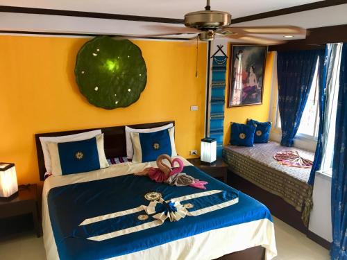 1 dormitorio con 1 cama con paredes azules y amarillas en Casa E Mare, en Kata Beach