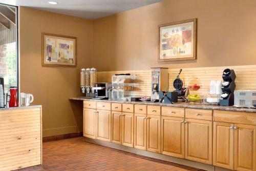 a kitchen with wooden cabinets and a counter top at Travelodge by Wyndham North Bay Lakeshore in North Bay