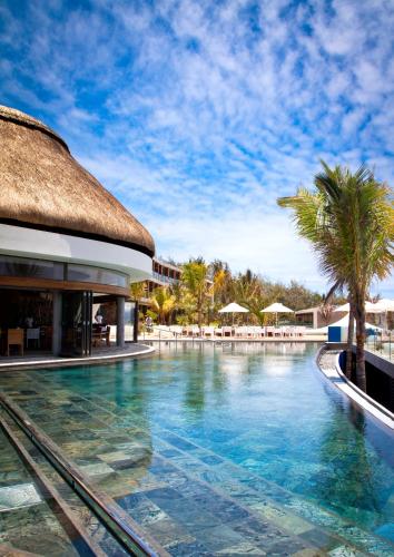 a swimming pool at a resort with palm trees at Radisson Blu Poste Lafayette Resort & Spa (Adults Only) in Poste Lafayette