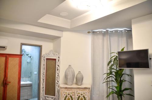 a bathroom with a mirror and a tv on a wall at Le Castel Blanc Hotel Boutique in San Andrés