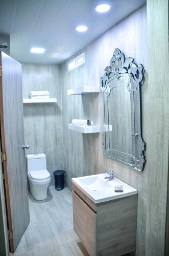 a bathroom with a sink and a toilet and a mirror at Le Castel Blanc Hotel Boutique in San Andrés