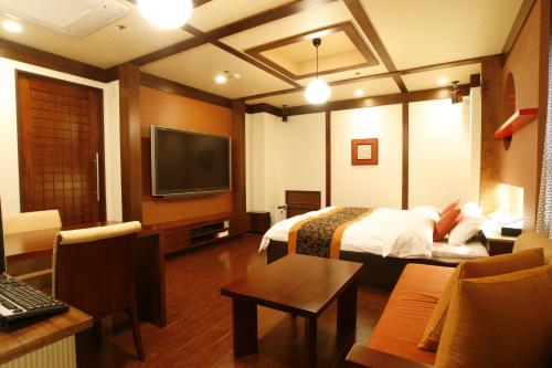 a hotel room with a bed and a flat screen tv at Hotel & Spa Lotus (Adult Only) in Kyoto