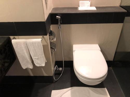 a bathroom with a white toilet and towels at The Zuri White Sands, Goa Resort & Casino in Varca