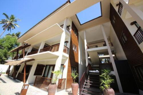 a building with stairs and plants in front of it at Eskala Hotels and Resorts in Ngwesaung