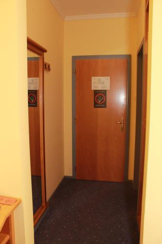 a hallway with a wooden door in a room at Hotel Prezident in Palić