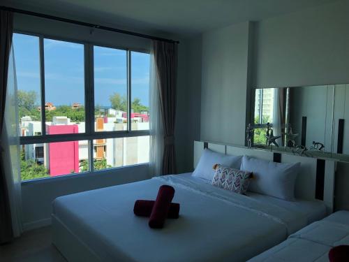 una camera da letto con un grande letto con una grande finestra di Baan Peang Ploen Huahin A 6/416 a Hua Hin