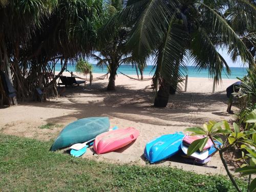 four surfboards are lined up on the beach at Villa Nilaveli Cabana in Nilaveli