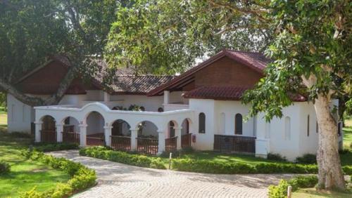 a large white house with a tree in front of it at Sanctum Inle Resort in Nyaung Shwe