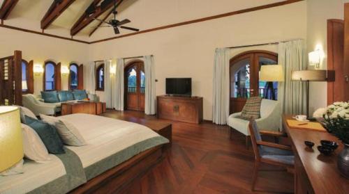 a bedroom with a large bed and a living room at Sanctum Inle Resort in Nyaung Shwe