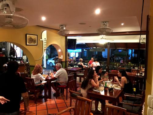a group of people sitting at tables in a restaurant at Casa E Mare in Kata Beach