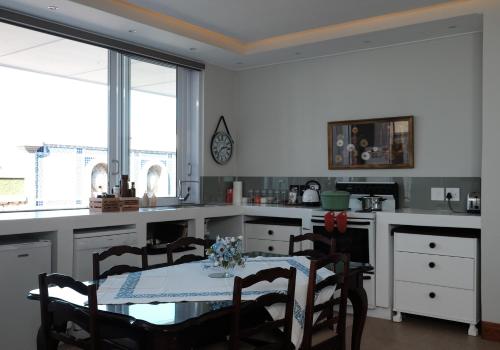 a kitchen with a table and some chairs and a table and a table at Nieuwerust in Prince Albert