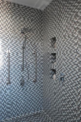a bathroom with a shower and a tiled wall at Nieuwerust in Prince Albert