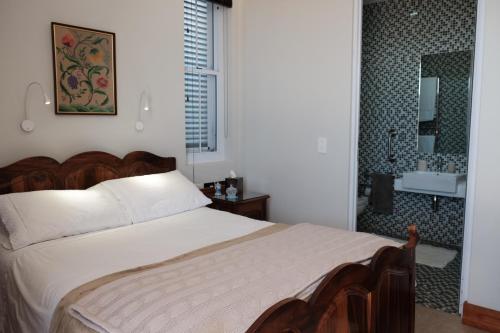 a bedroom with a bed and a bathroom with a shower at Nieuwerust in Prince Albert