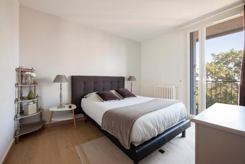 une chambre blanche avec un grand lit et une fenêtre dans l'établissement T4 refait à neuf Rennes, 3 ch. parking, 2 balcons., à Rennes