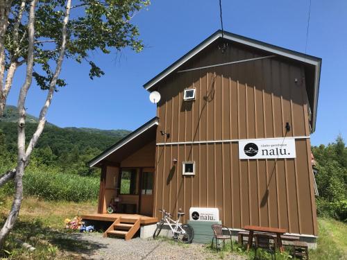 a building with a sign on the side of it at Niseko Guesthouse Nalu. in Niseko