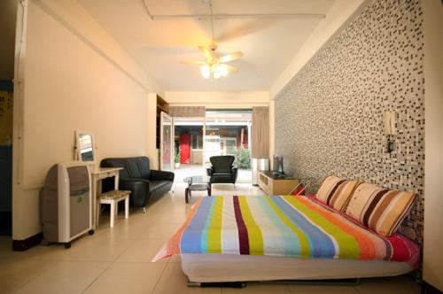 a bedroom with a bed and a living room at Miaoli Sanyi Shantongyazhu Homestay in Sanyi
