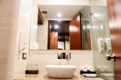 een badkamer met een wastafel en een spiegel bij Hotel Ascent Biz in Noida