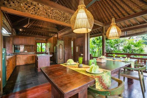 een keuken met een grote houten tafel in een kamer bij Aryaswara Villa Ubud in Ubud