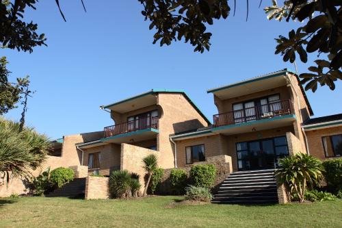 a large brick building with stairs and balconies at First Group Club Hacienda in Shelly Beach
