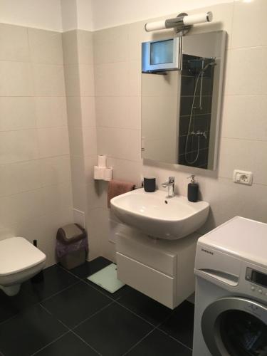 a bathroom with a sink and a washing machine at Apartment Victoria in Victoria