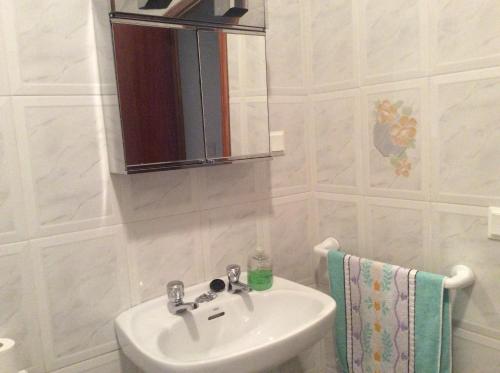 エル・ボスケにあるCasa Vicente el Bosqueのバスルーム(シンク、鏡、タオル付)