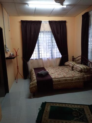 um quarto com uma cama em frente a uma janela em De La Homestay em Alor Setar