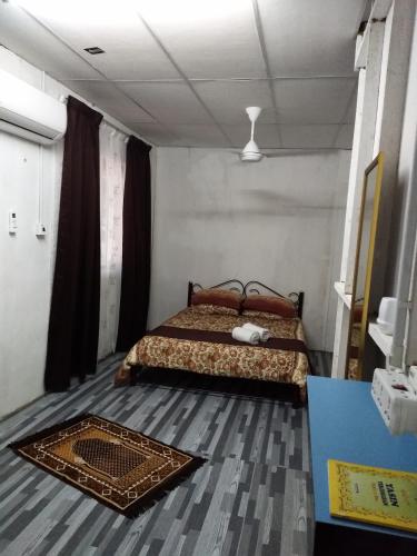 1 dormitorio con cama y alfombra en el suelo en De La Homestay en Alor Setar