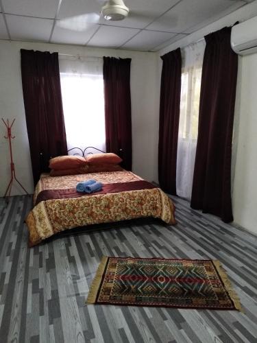 a bedroom with two beds and a rug on the floor at De La Homestay in Alor Setar