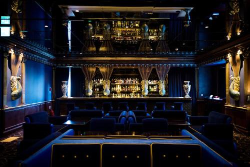 a room with blue chairs and a bar at L'Escape Hotel in Seoul