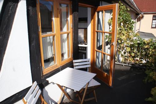 een tafel en stoelen op het balkon van een huis bij Herberge KAFFETIET in Wismar