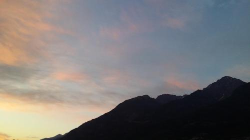 a sunset over the mountains with a cloudy sky at La Casa Del Grillo 1 in Aosta
